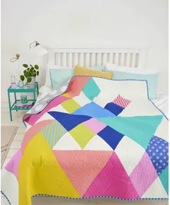 End Game Quilt Pattern by Tied With A Ribbon - made quilt shown on a bed
